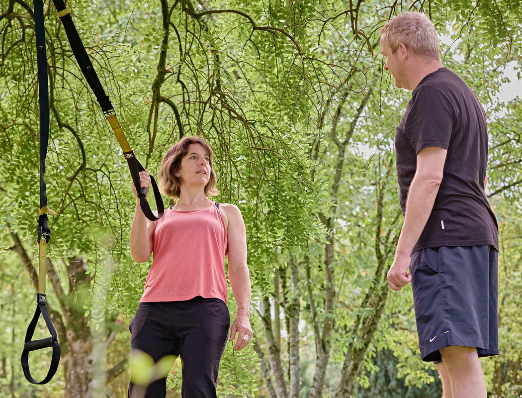 Sarah Hänggi beim TRX-Training mit einem Kunden im Park in Basel